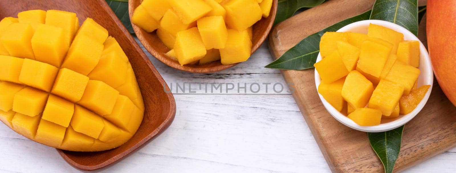 Fresh chopped mango on a tray and bright rustic wooden background. Tropical summer fruit design concept, close up, macro, copy space. by ROMIXIMAGE