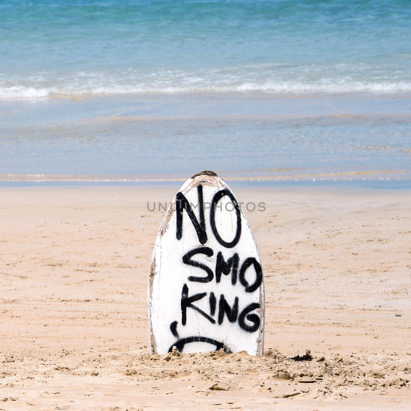No Smoking warning sign on white surfboard at the beach in summer, concept of sea environmantal protection design, copy space, lifestyle. by ROMIXIMAGE