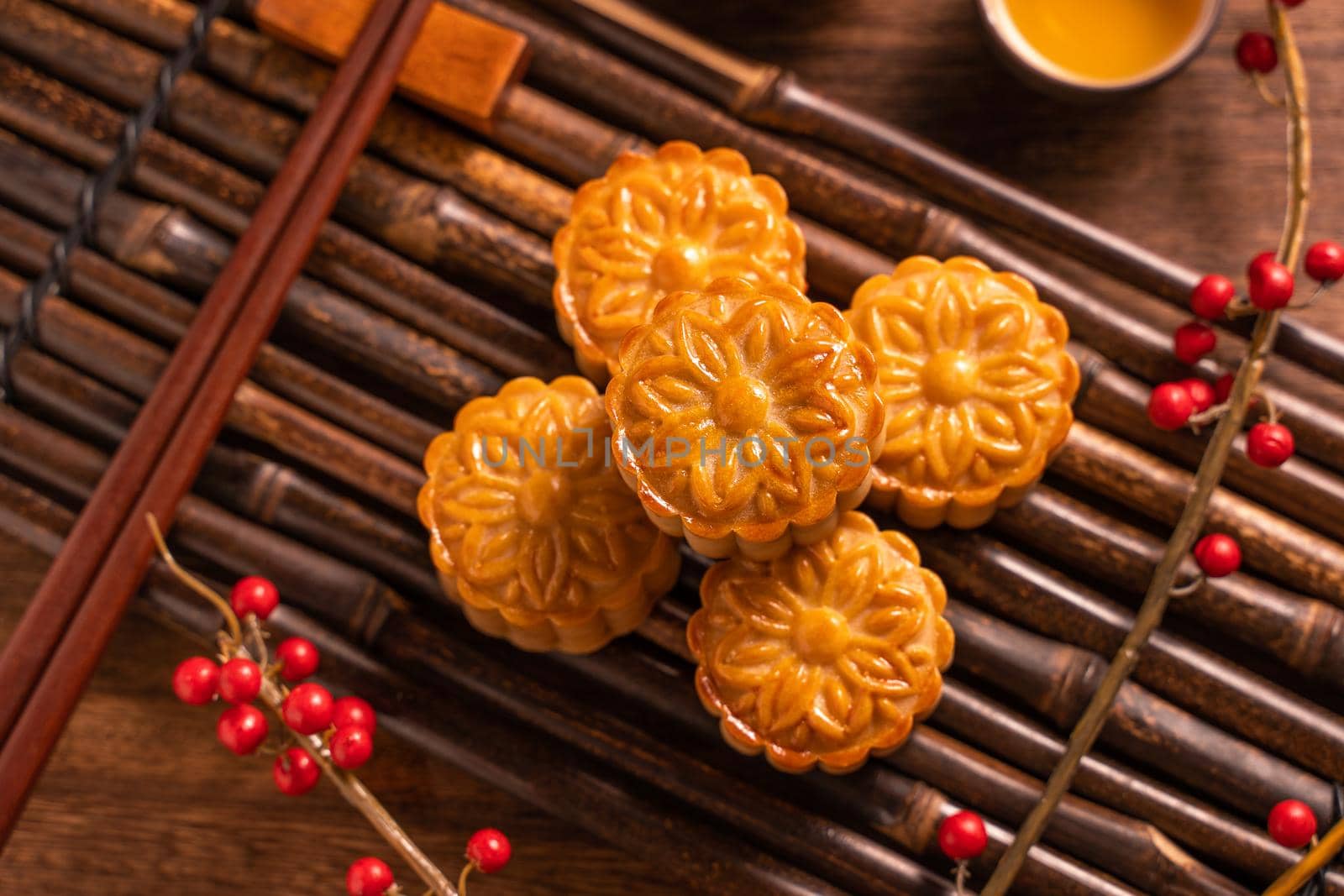 Chinese traditional pastry Moon cake Mooncake with tea cups on bamboo serving tray on wooden background for Mid-Autumn Festival, top view, flat lay. by ROMIXIMAGE