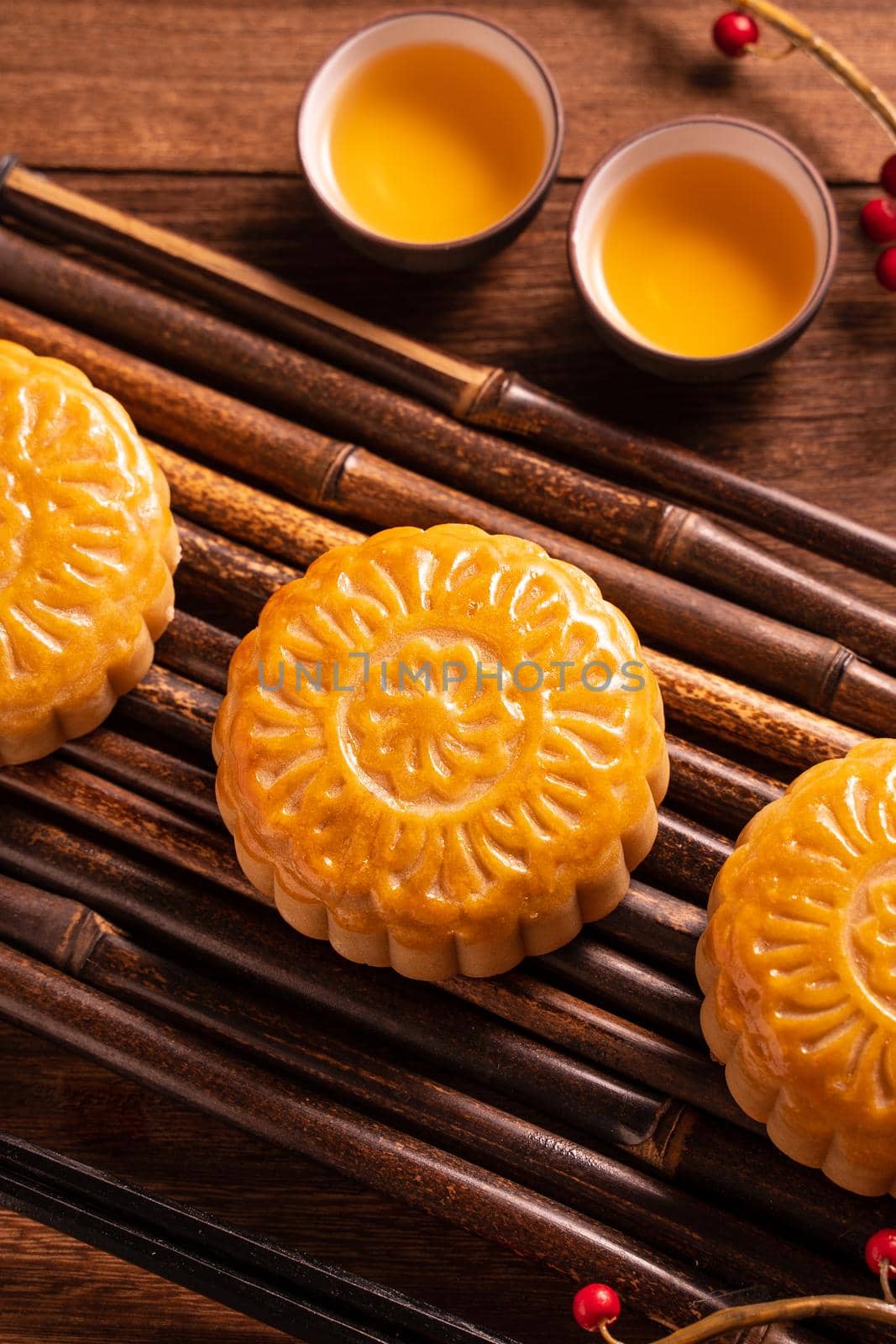 Chinese traditional pastry Moon cake Mooncake with tea cups on bamboo servingwarning tray on wooden background for Mid-Autumn Festival, close up.