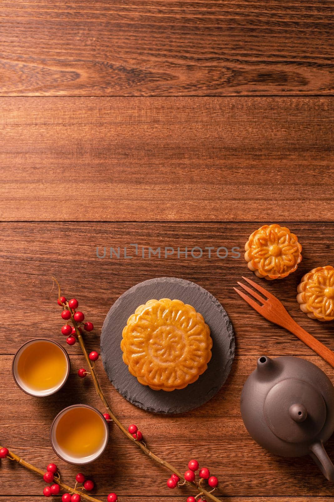 Chinese traditional pastry Moon cake Mooncake with tea cups on bamboo serving tray on wooden background for Mid-Autumn Festival, top view, flat lay. by ROMIXIMAGE