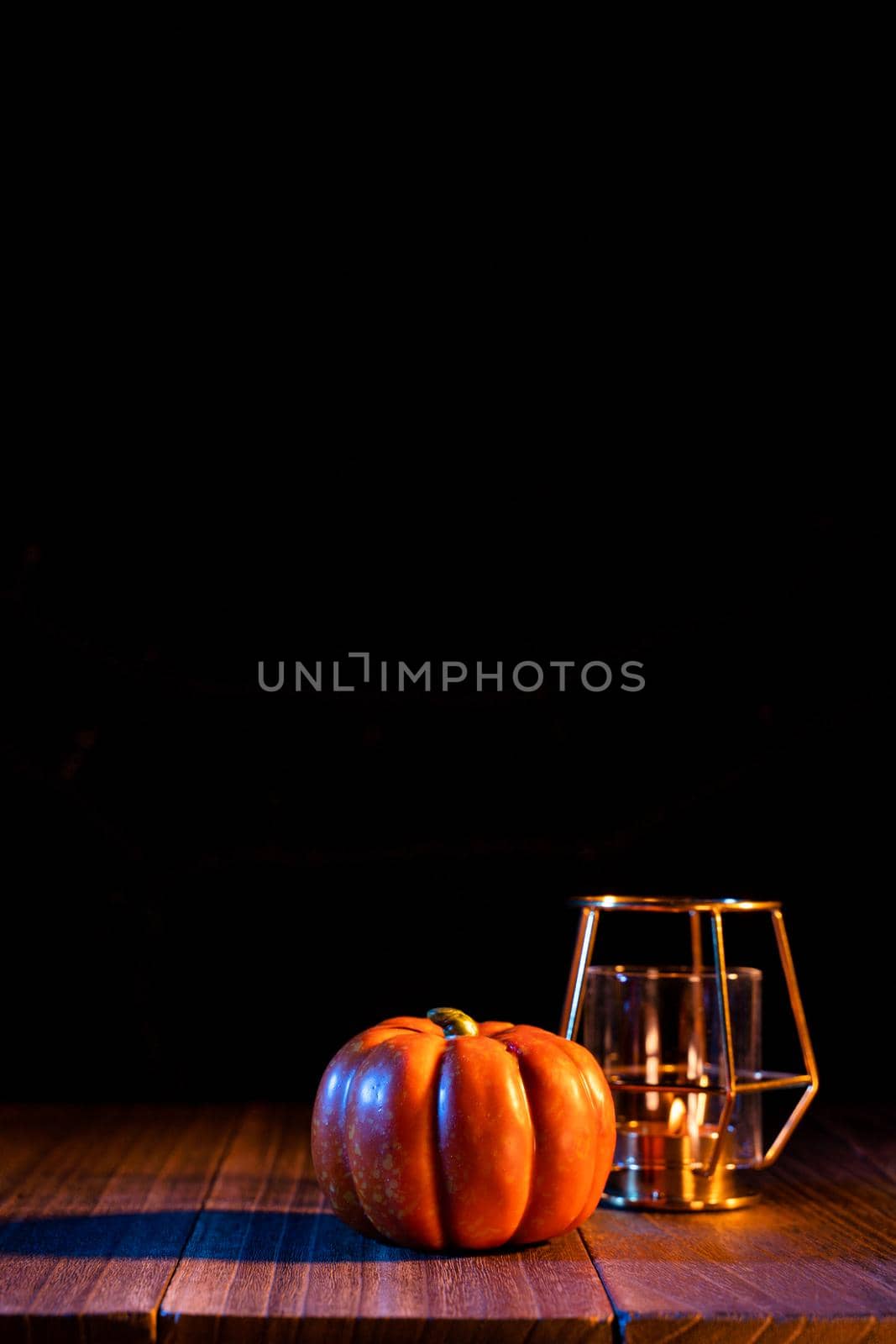 Halloween concept - Orange pumpkin lantern on a dark wooden table with black background, trick or treat, close up.