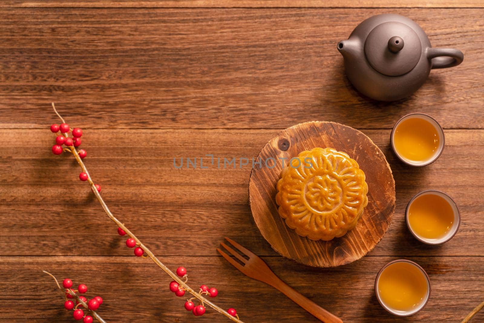 Chinese traditional pastry Moon cake Mooncake with tea cups on bamboo serving tray on wooden background for Mid-Autumn Festival, top view, flat lay.