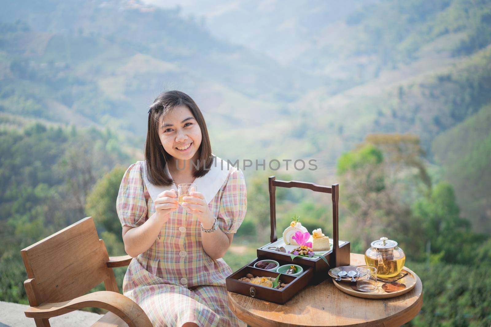 beautiful women drinking hot green tea sitting on the chair mountain view