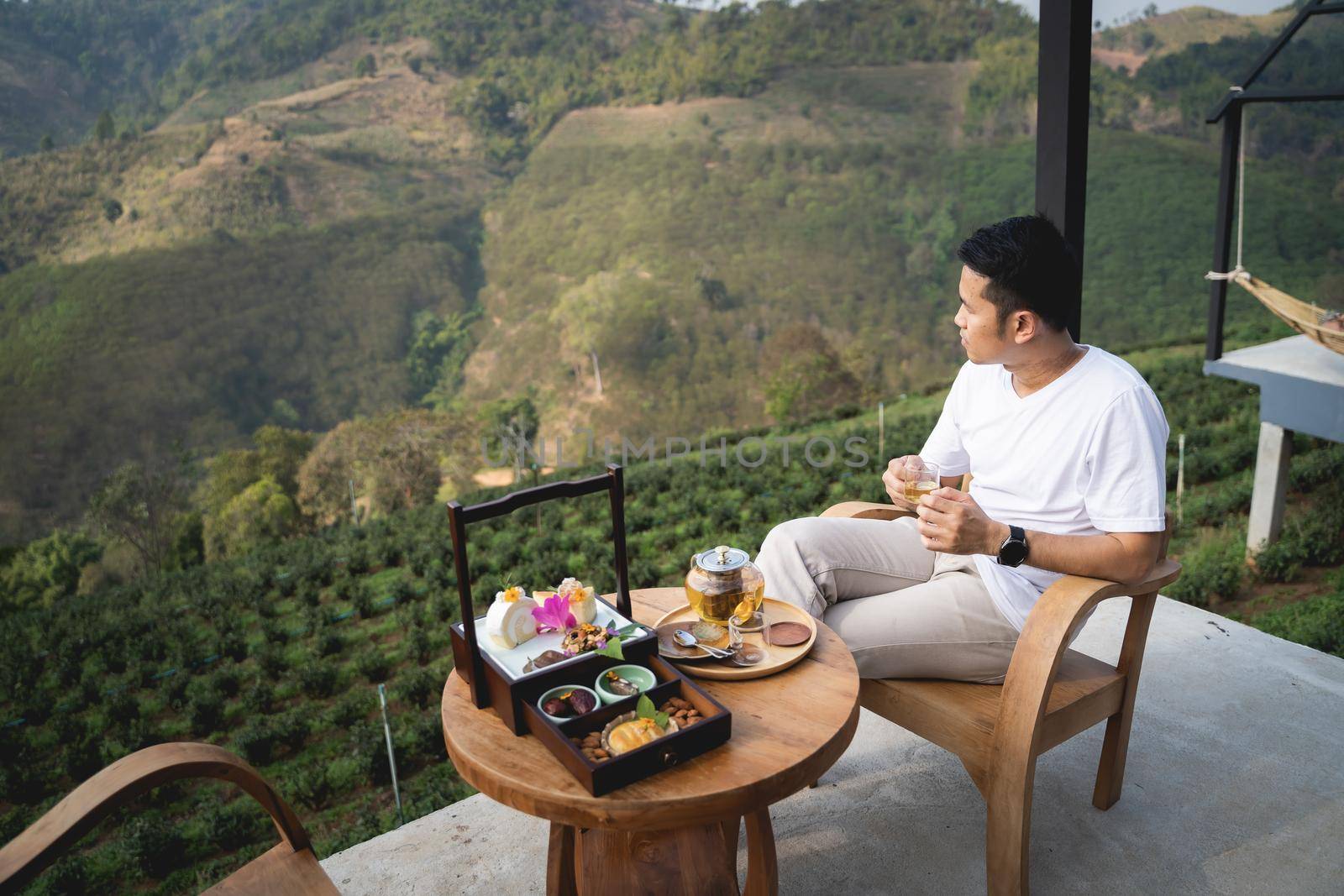 the man drinking hot green tea sitting on the chair mountain view by Wmpix