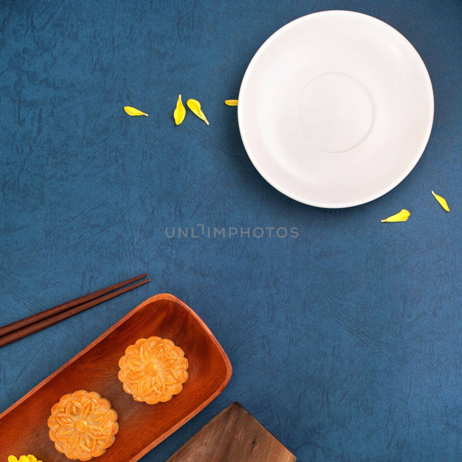 Minimal simplicity layout moon cakes on blue background for Mid-Autumn Festival, creative food design concept, top view, flat lay, copy space.