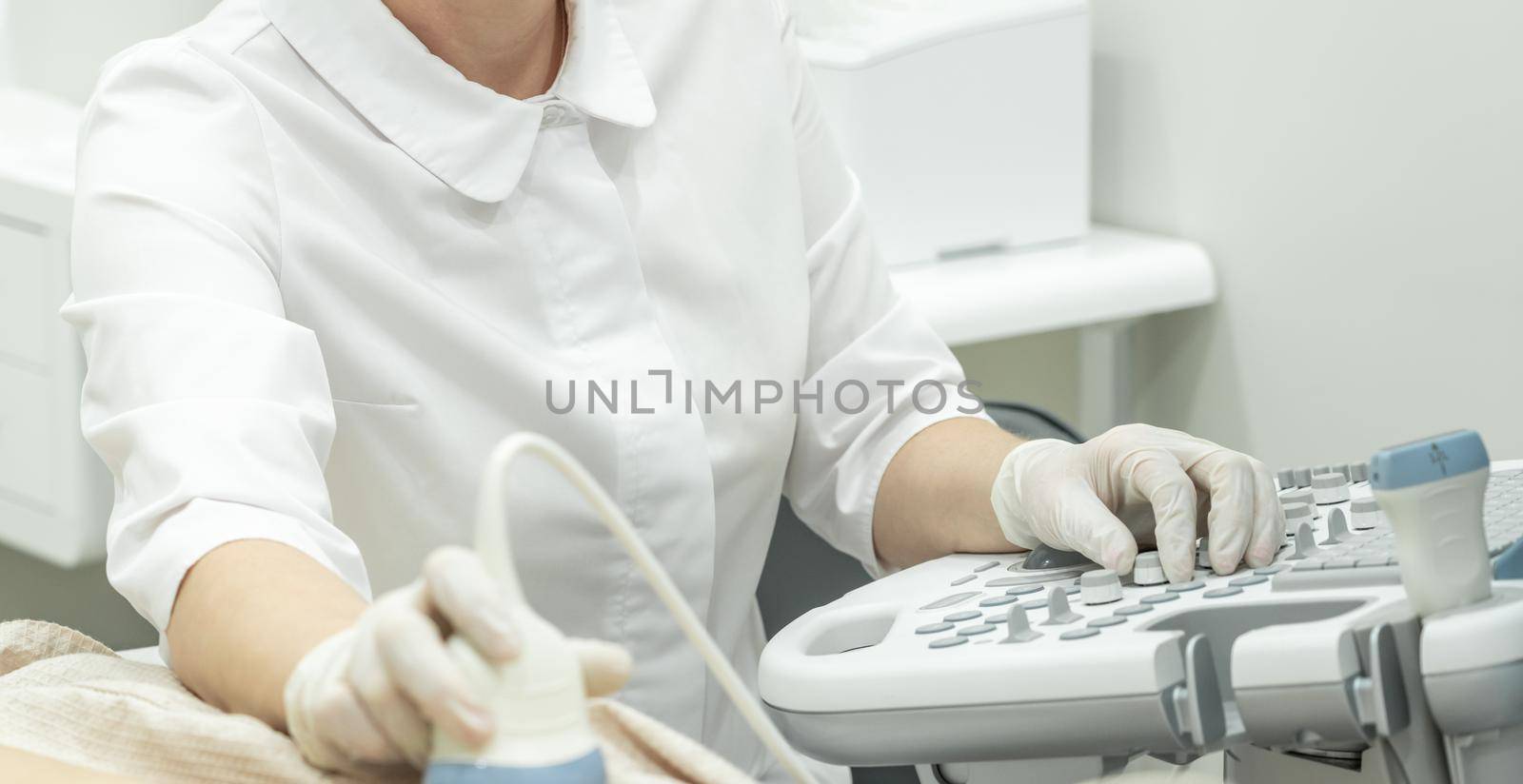Doctor operating Ultrasound scanner for patient diagnostic by Mariakray