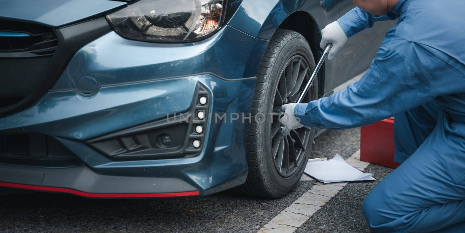 Man mechanic changing wheels after car breakdown. by Sorapop