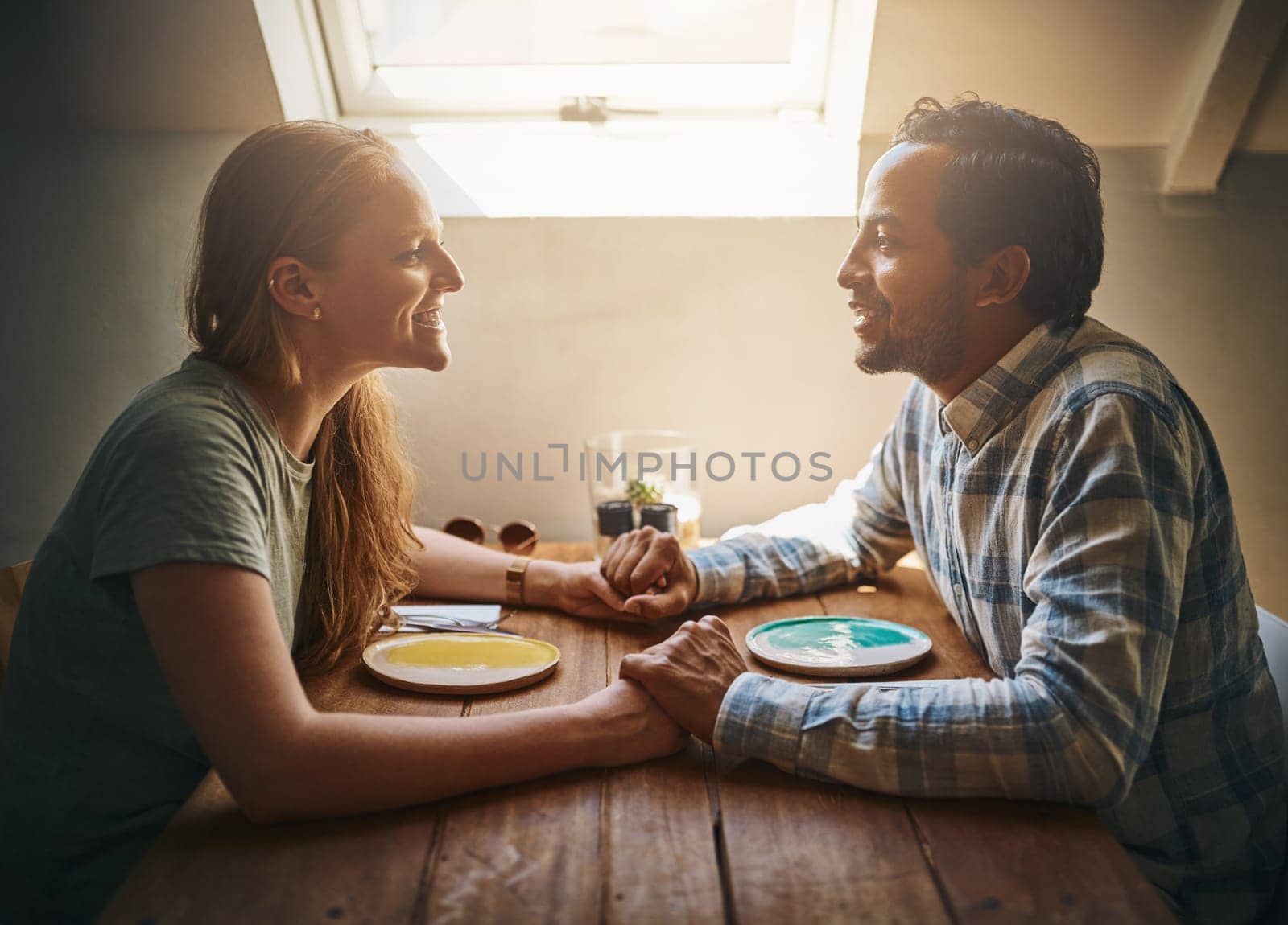 Love, couple and holding hands at cafe on table, talking and bonding together. Valentines day, romance diversity and affection of man and woman on date, having fun or enjoying time in restaurant