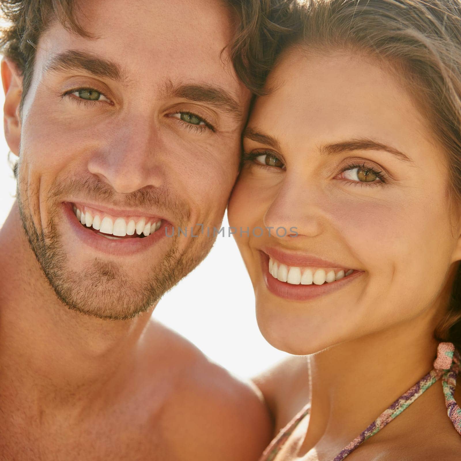 Match made in heaven. Closeup portrait of a loving young couple enjoying a sunny day at the beach together. by YuriArcurs