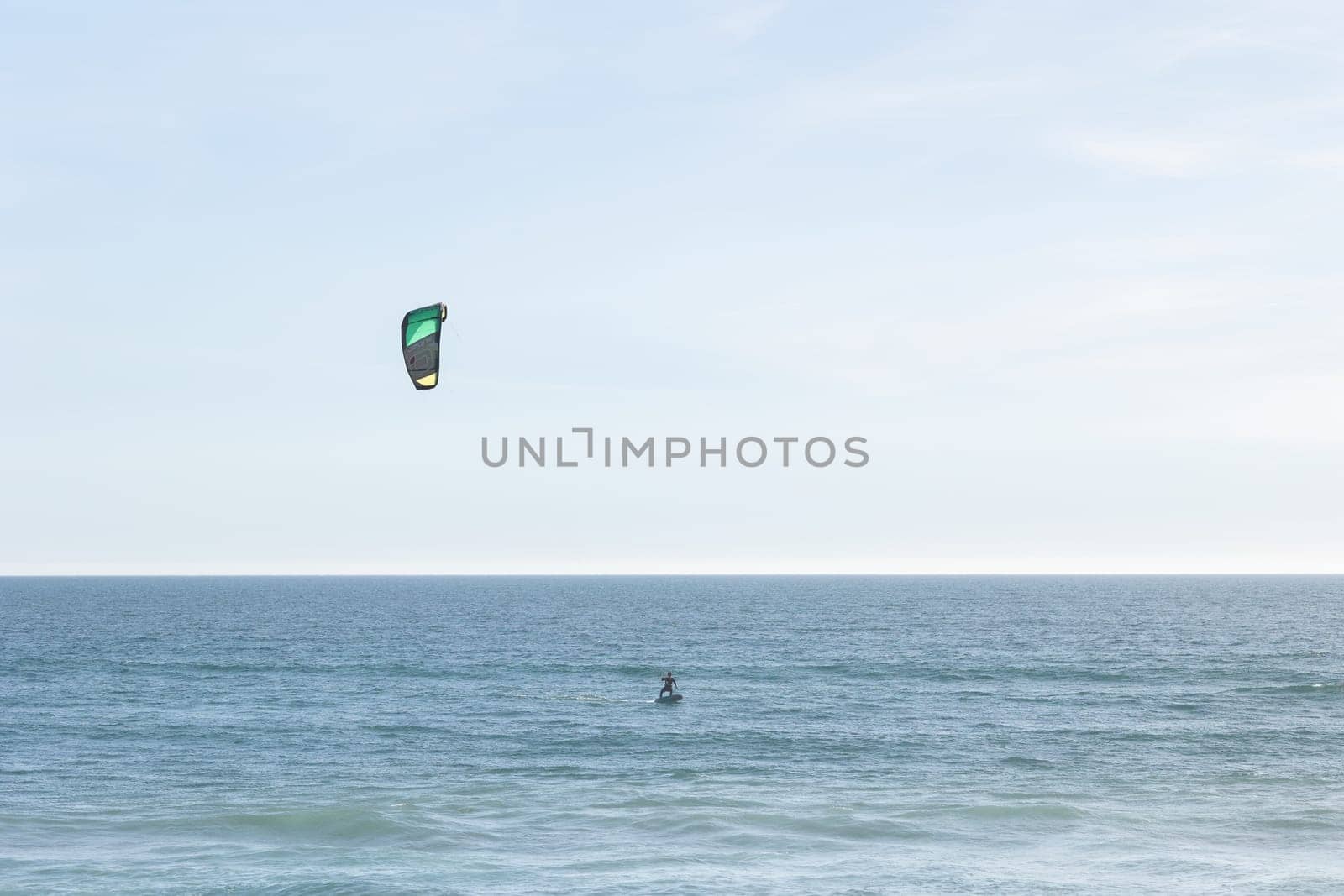 A person kitesurfing in the sea. Mid shot