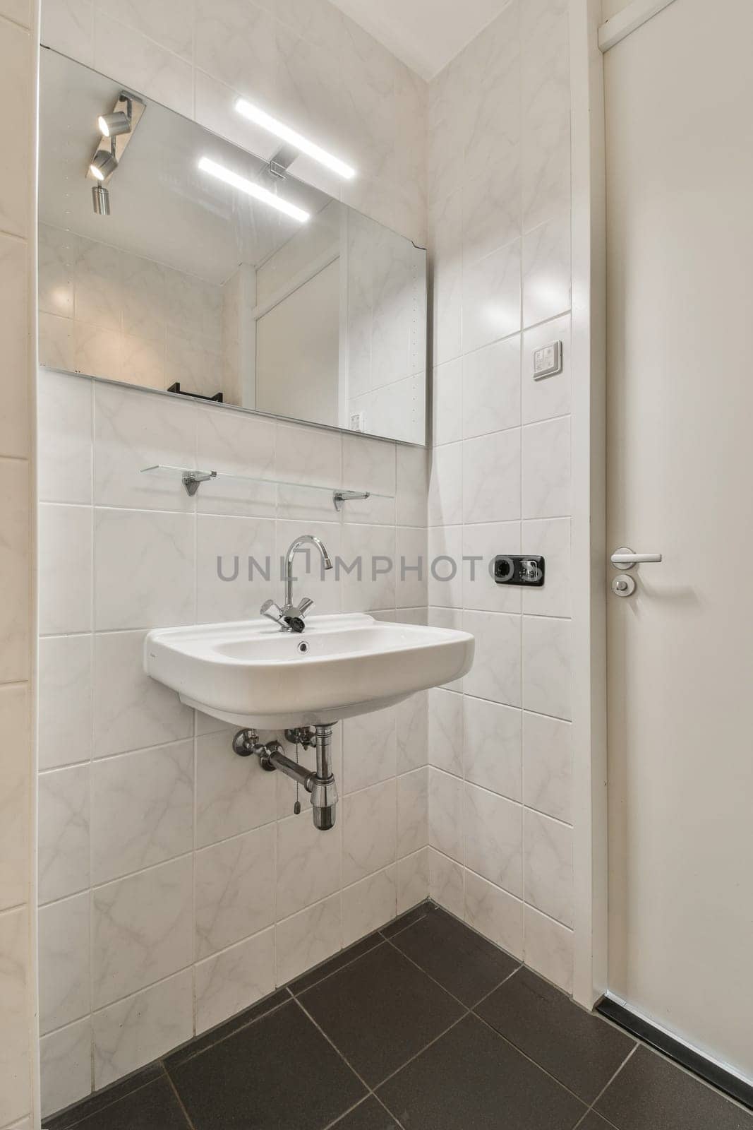 a bathroom with a sink and mirror on the wall next to an open door that leads to a walk - in shower