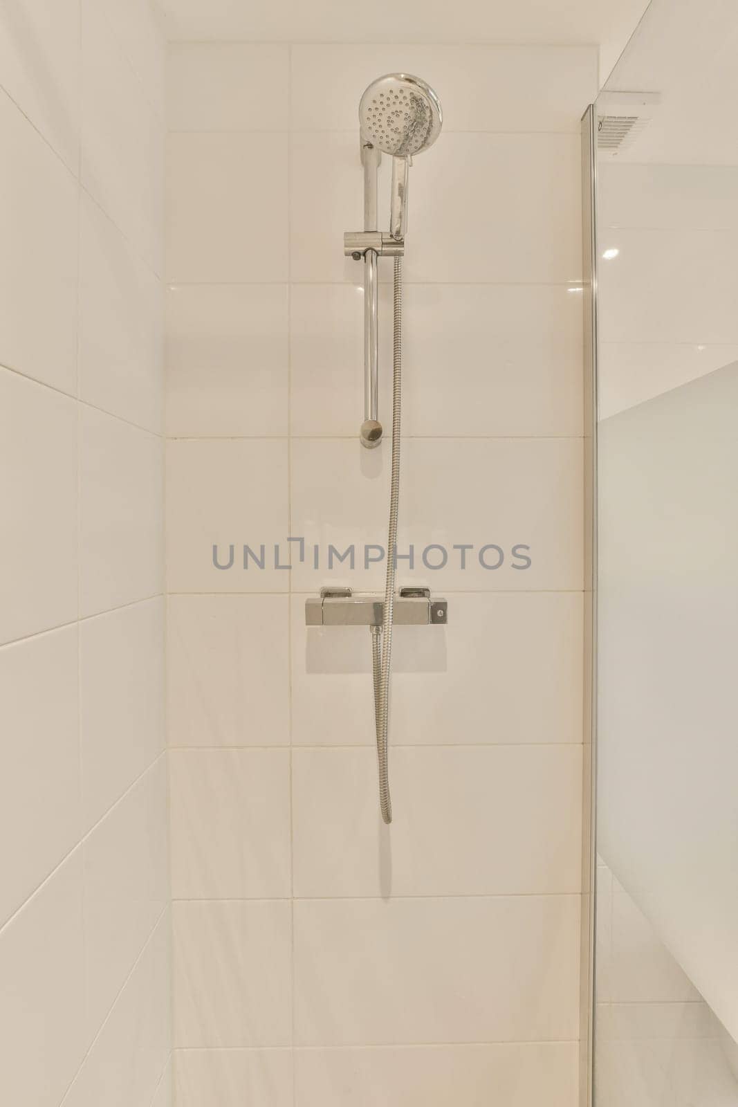 a shower with a glass door in a white bathroom by casamedia