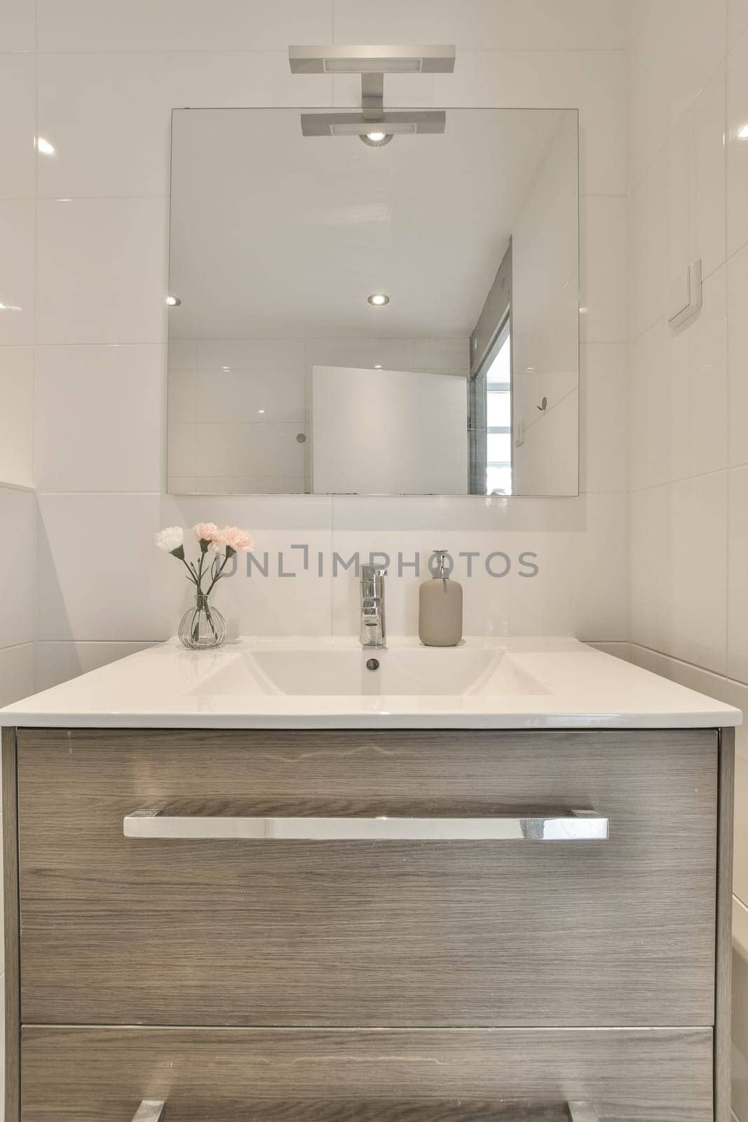 a bathroom with a sink and mirror above the counter area in front of the sink is white tiles on the wall