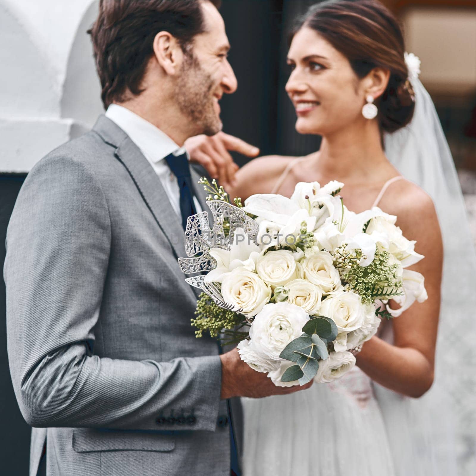 Flowers, wedding and love with a married couple standing outdoor together after a ceremony of tradition. Love, marriage or commitment with a man and woman outside looking happy as husband and wife by YuriArcurs