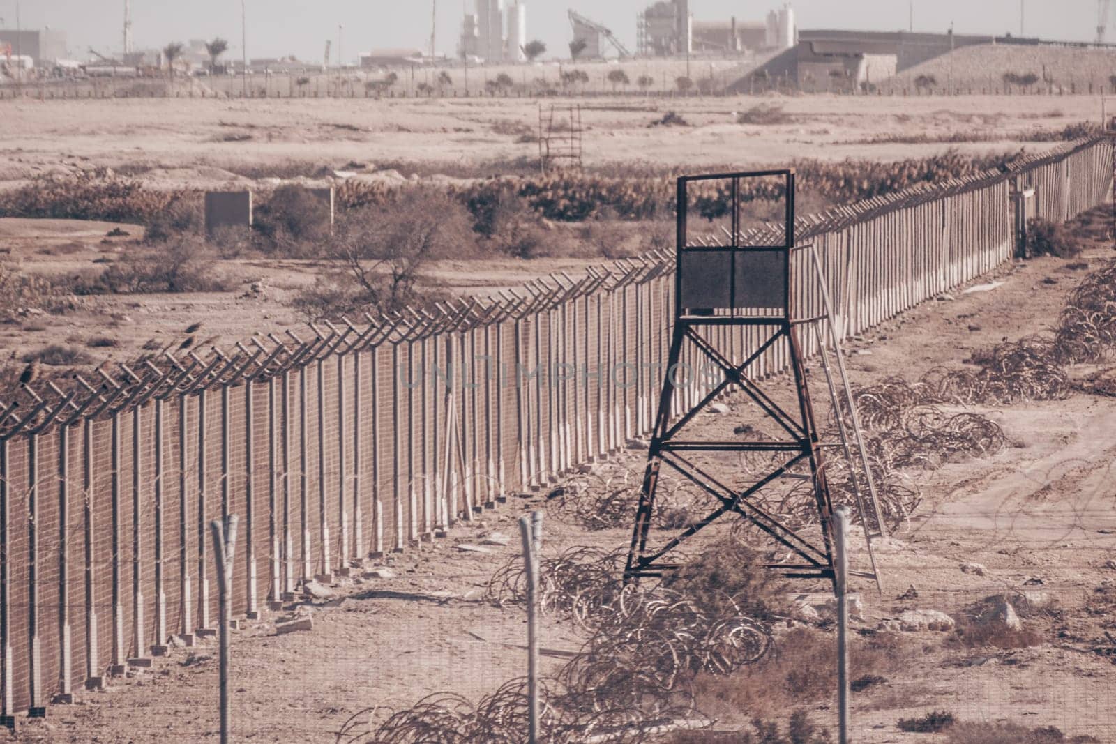 Fanced bordeline, barbed wires and watchtower. Non-passable military zone.