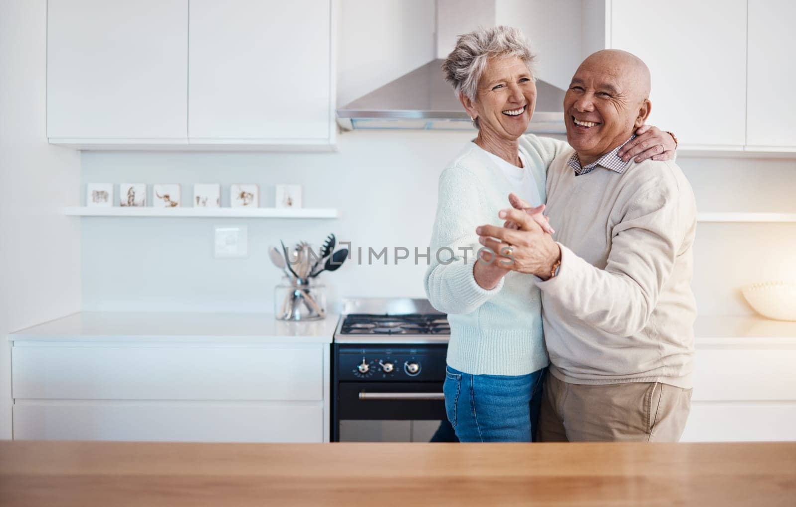 Love, dance and portrait of old couple in kitchen at home, weekend time and celebrate romance with smile. Retirement, happiness and health, happy man and senior woman dancing in house or apartment. by YuriArcurs