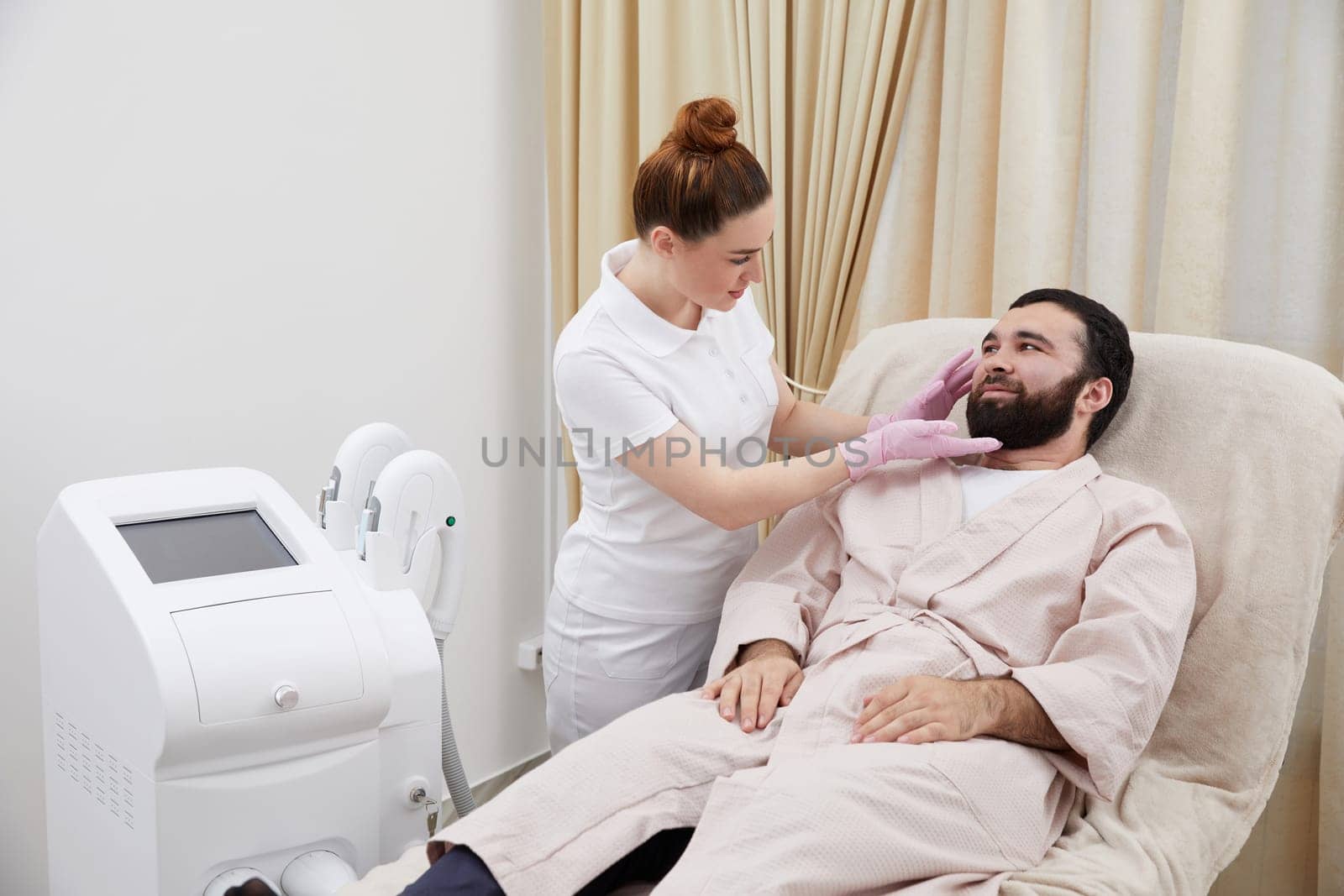 Consultation in cosmetology clinic. Female professional beauty doctor talking with pretty young men by Mariakray