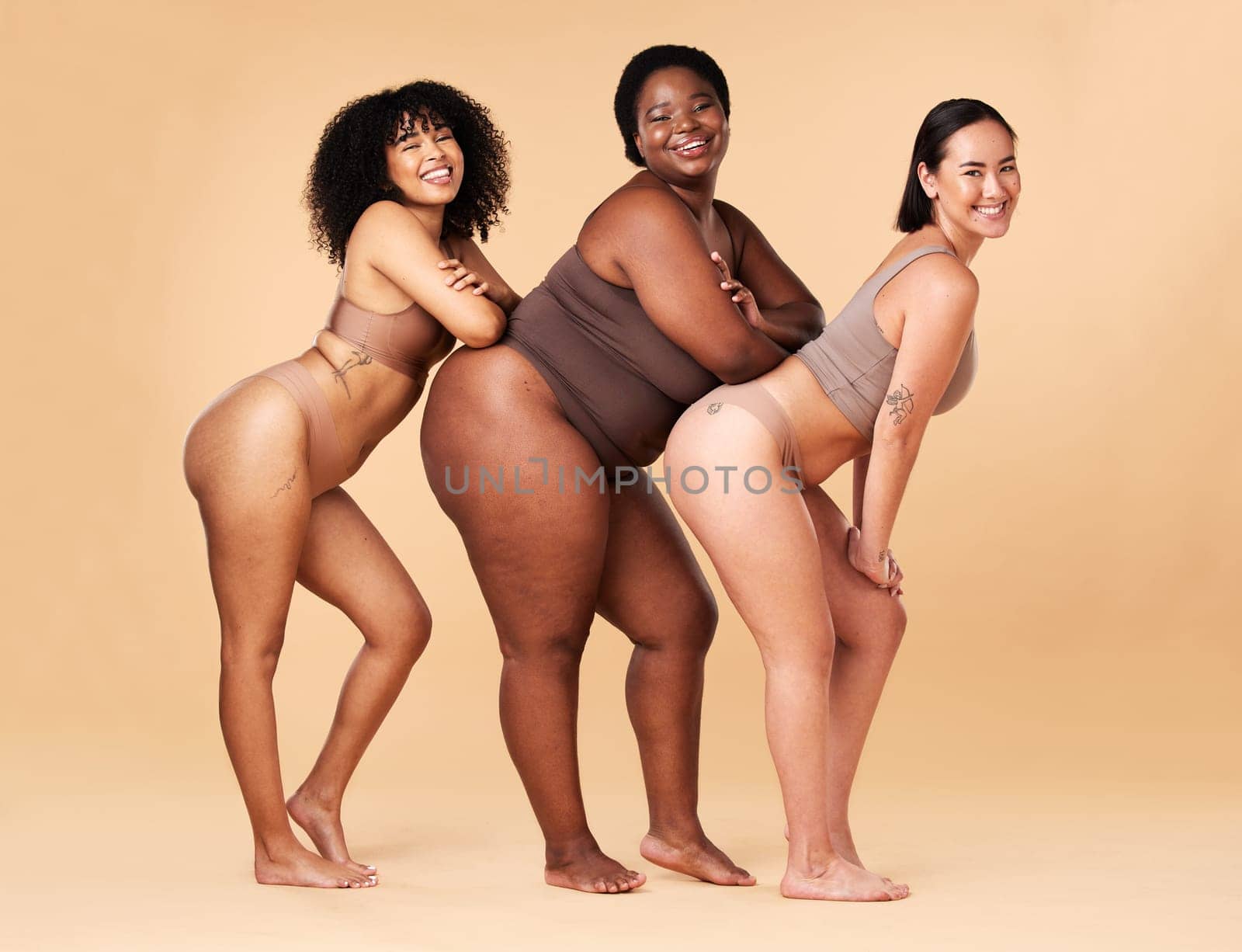 Diversity women, body size and portrait of group together for inclusion, beauty and power. Underwear model friends happy on beige background with cellulite legs, skin pride and self love motivation.