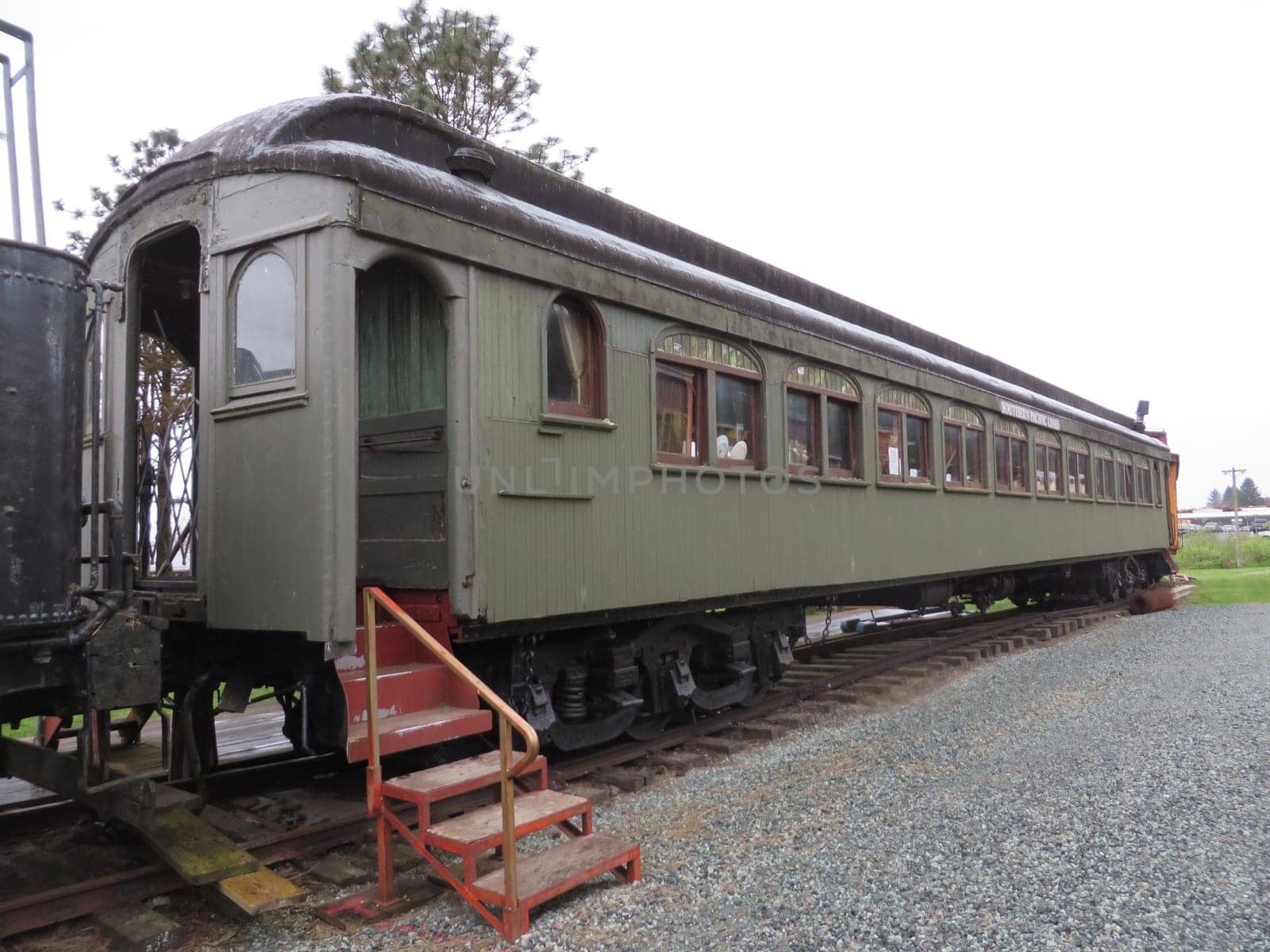 Historic Wooden Green Passenger Train Car on a Gloomy Day, Oregon Coast Scenic Railroad . High quality photo