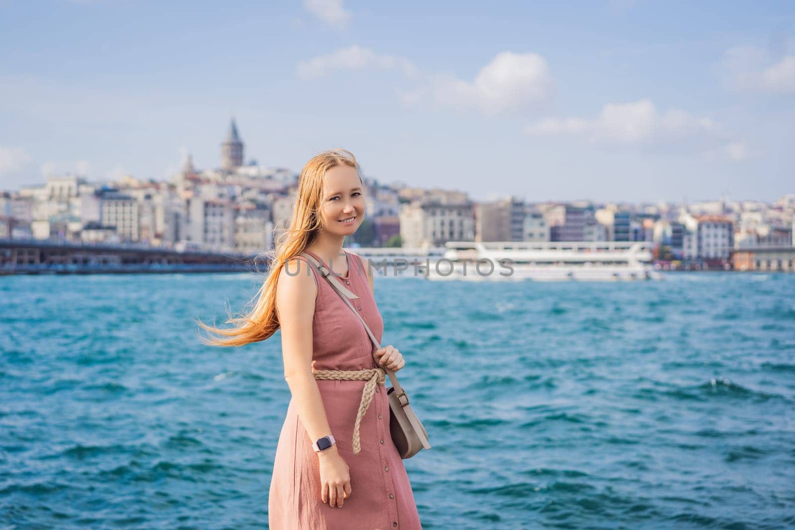 Portrait of beautiful woman tourist with view of Galata tower in Beyoglu, Istanbul, Turkey. Turkiye.