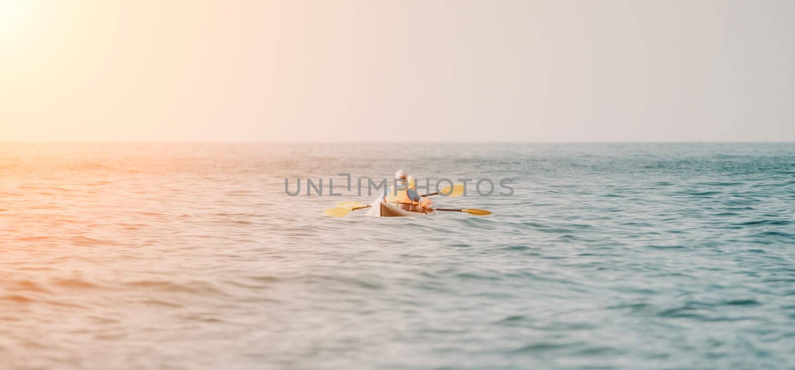 Kayaks. Couple kanoeing in the sea near the island with mountains. People kayaking in the ocean.