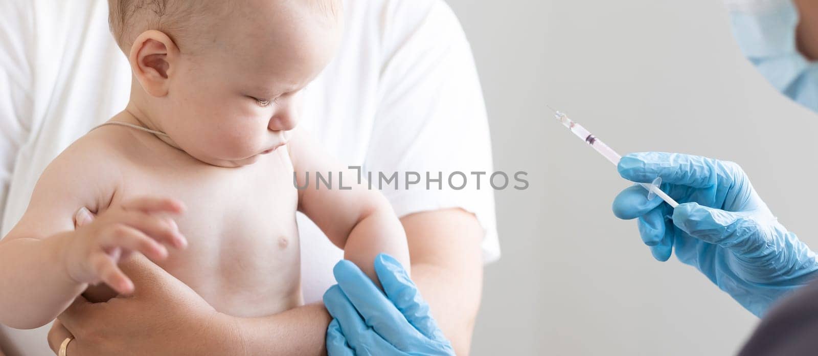 The doctor makes a baby vaccination on a white background