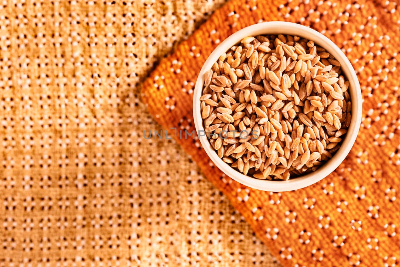  Uncooked spelt in bowl on colored background,  ,cereal grains ,