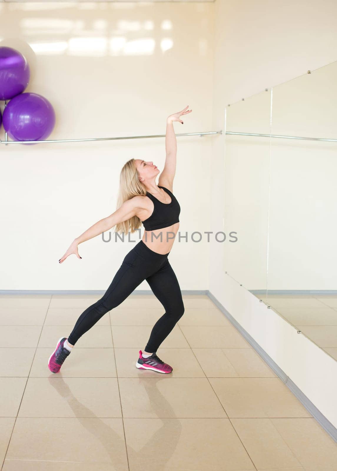 woman is engaged in sports dancing in the gym, fitness club. Zumba dance fitness instructor doing sport aerobic exercises. motivational coach. by aprilphoto