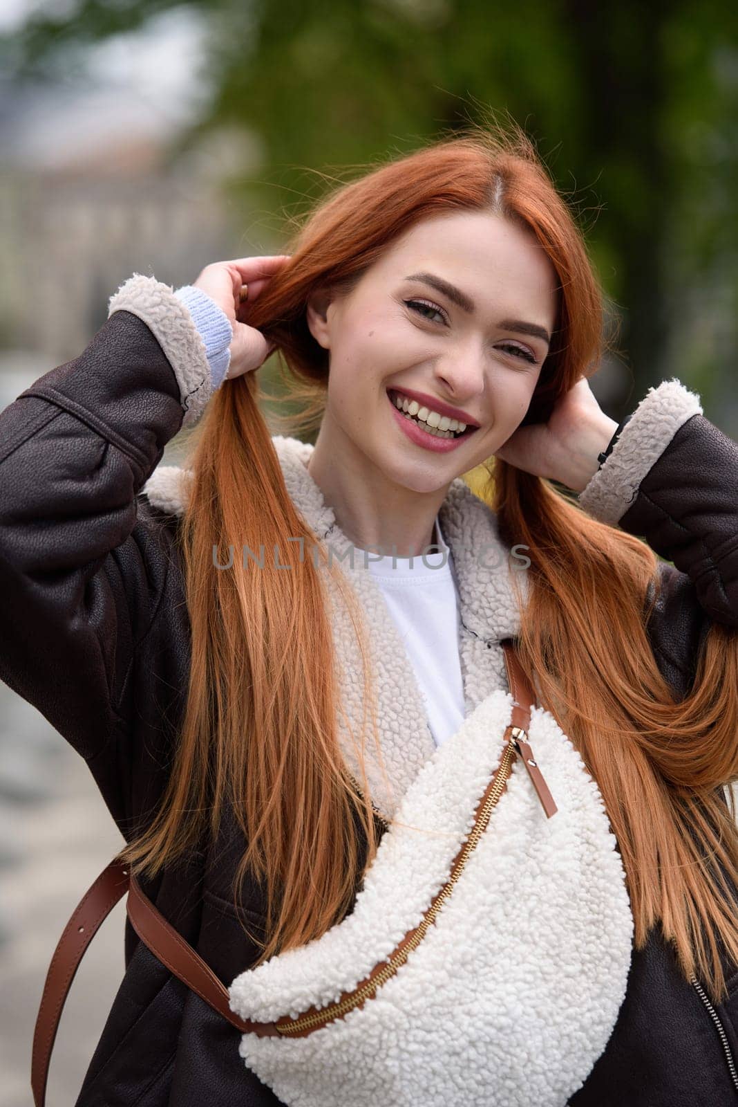 a red-haired girl in a leather jacket. cheerful woman with long red hair poses for a photographer by Ashtray25