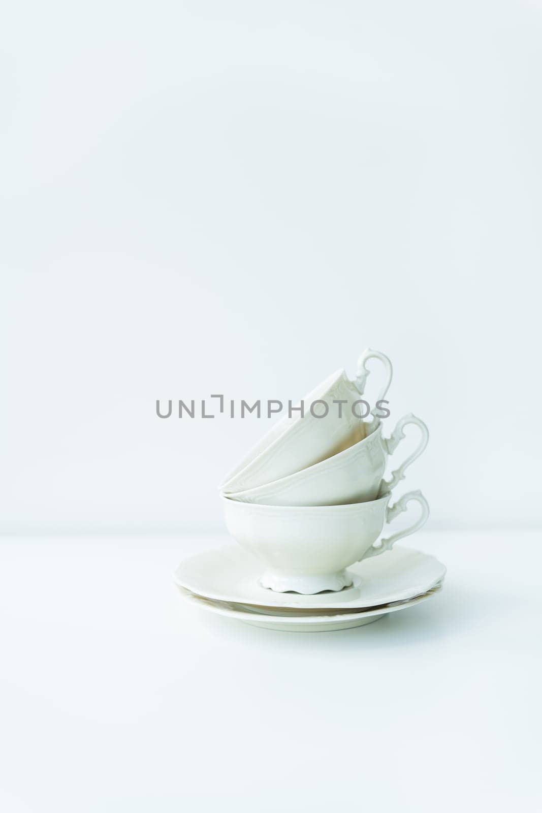 A set of cream porcelain cups with saucers on the table, preparation for the tea ceremony, top view. by sfinks