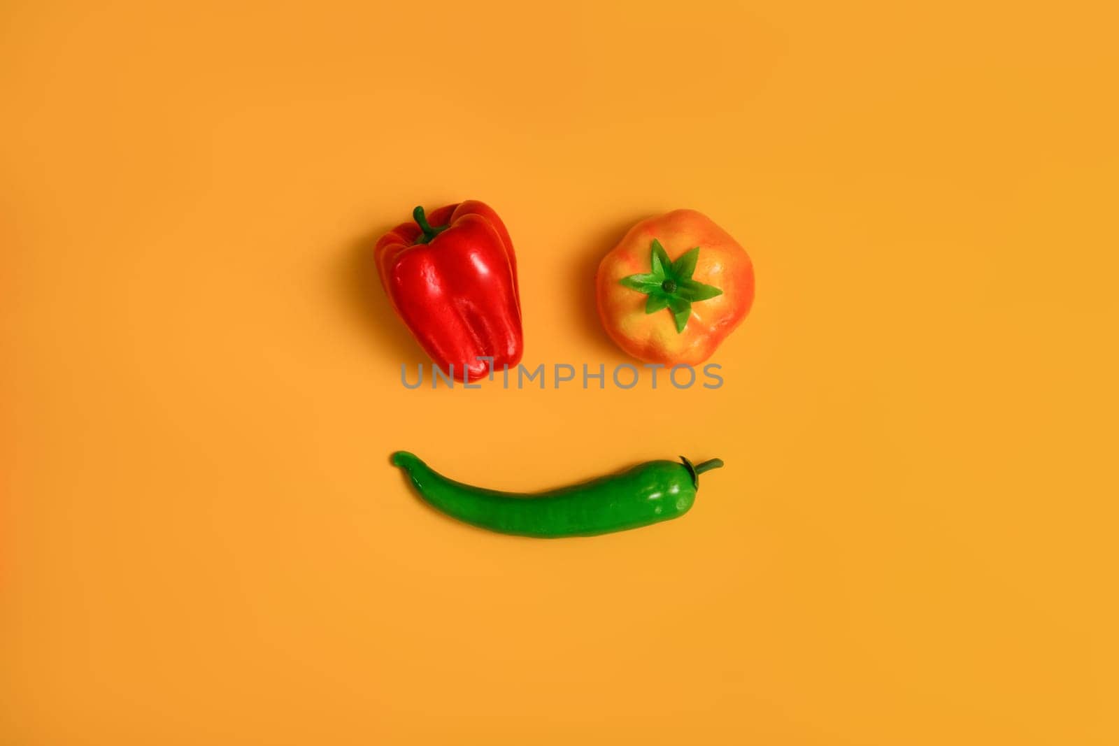 Red, yellow sweet pepper and green chili pepper isolated on yellow background. Healthy food background, vegetable concept.
