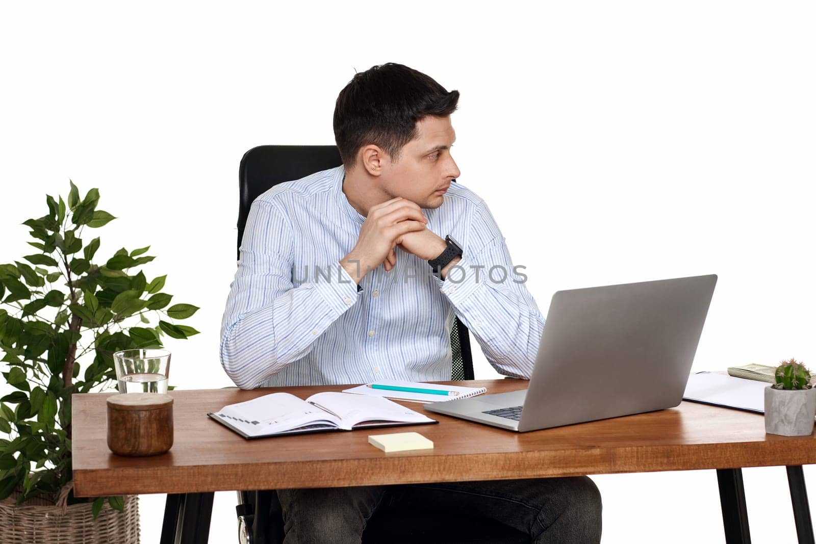 sad businessman using laptop, sitting on chair at desk, having problems thinking about troubles in office