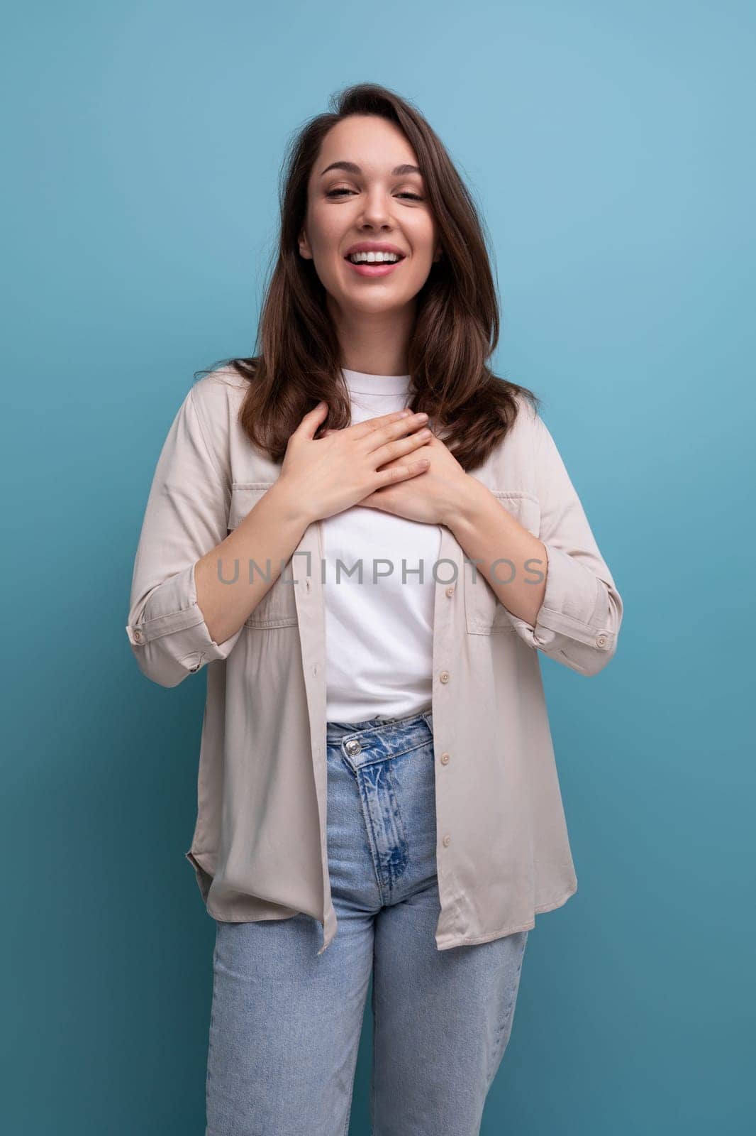 smiling caucasian young brunette woman in shirt and jeans.