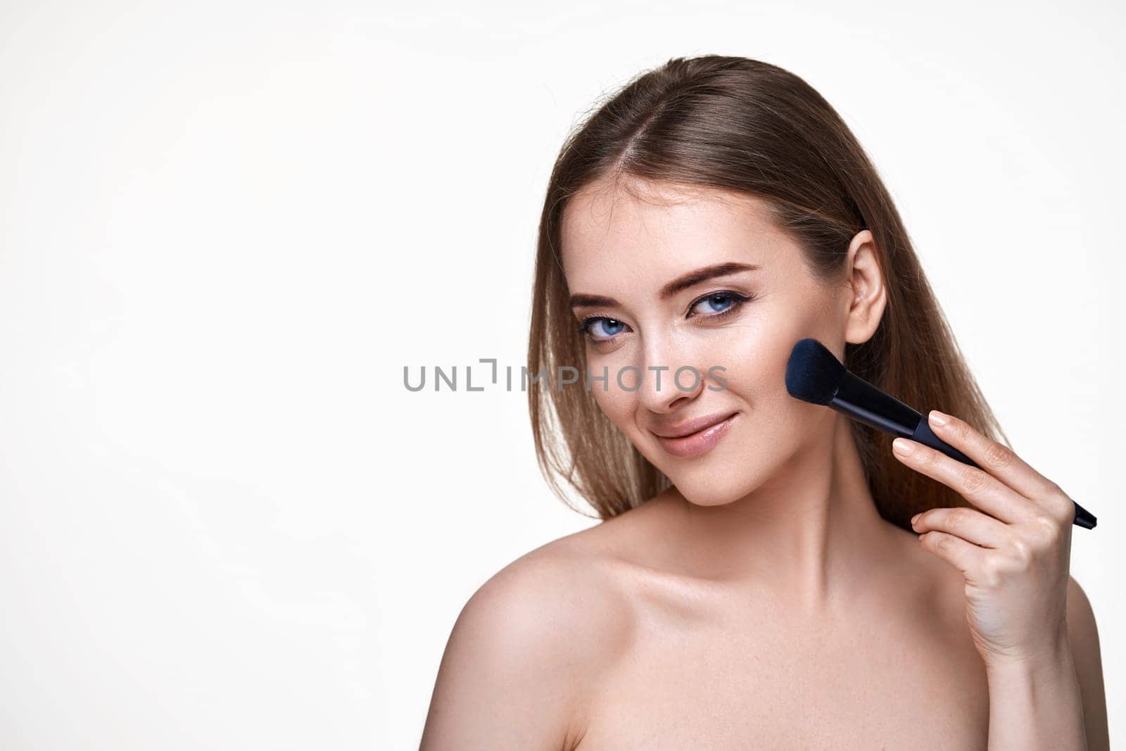 smiling lovely woman posing with make-up brush for powder isolated on white background. copy space