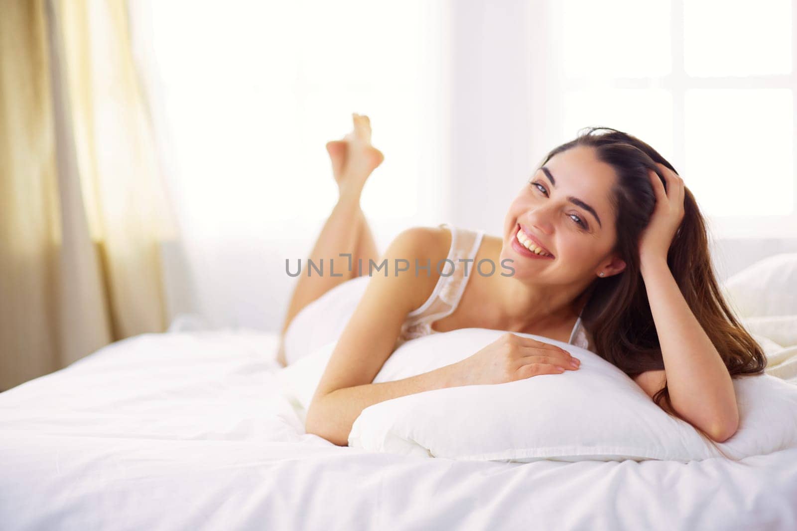 Pretty woman lying down on her bed at home.