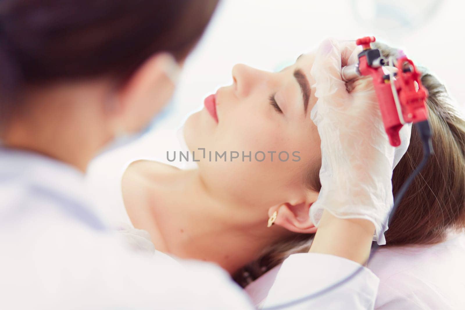 A young girl having red lips permanent makeup, micropigmentation.