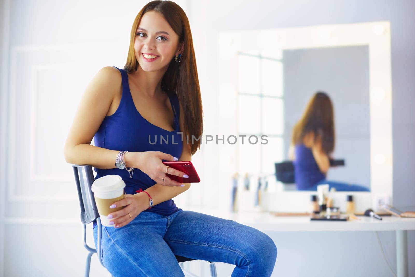 Young woman at cafe drinking coffee and talking on the mobile phone.
