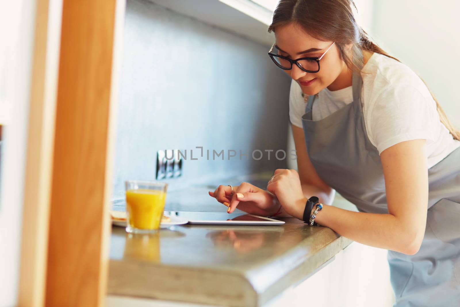 Portrait of young attractive caucasian brunette housewife at kitchen. Morning with cup of coffee and tablet pc.