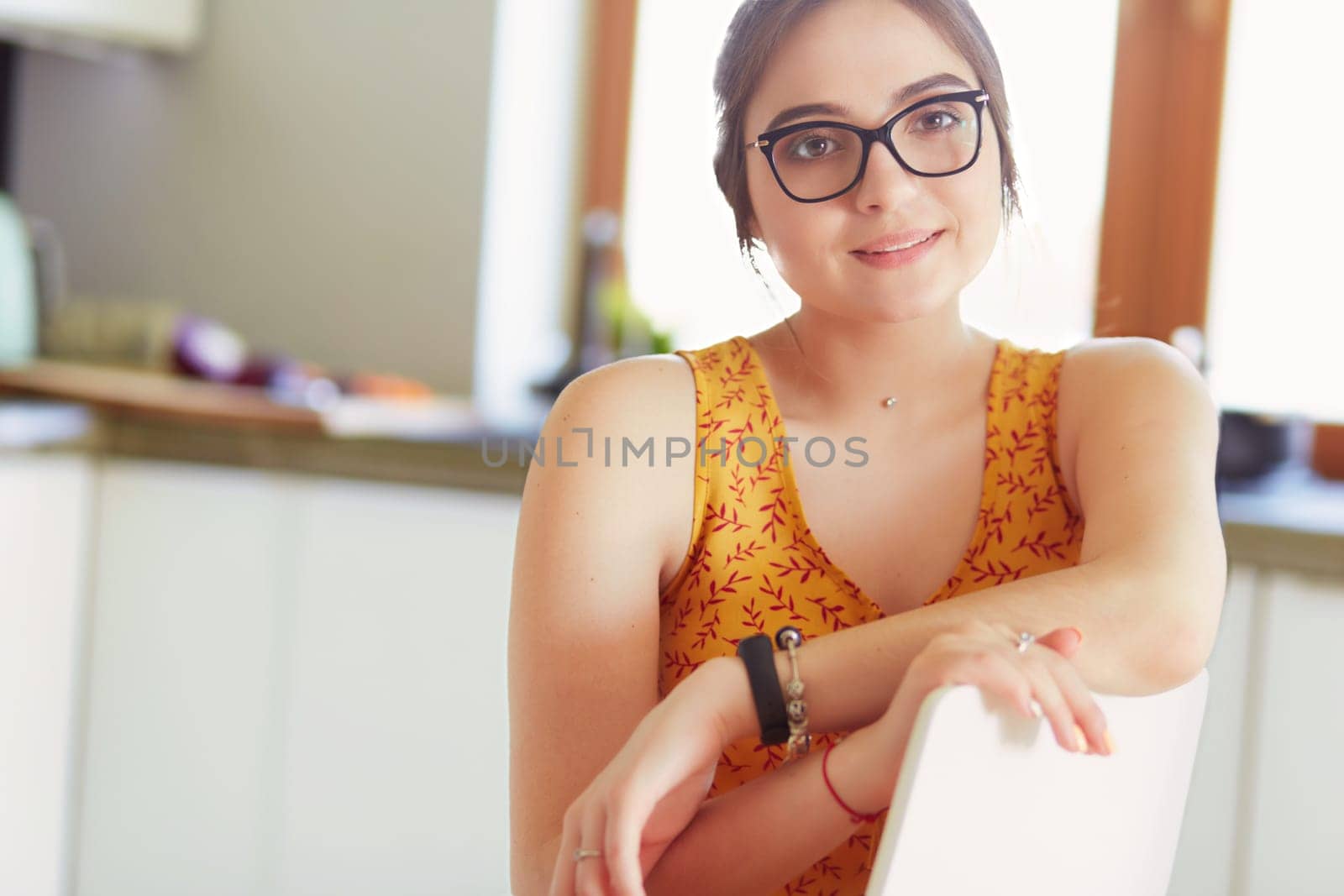 Young woman sitting a table in the kitchen .
