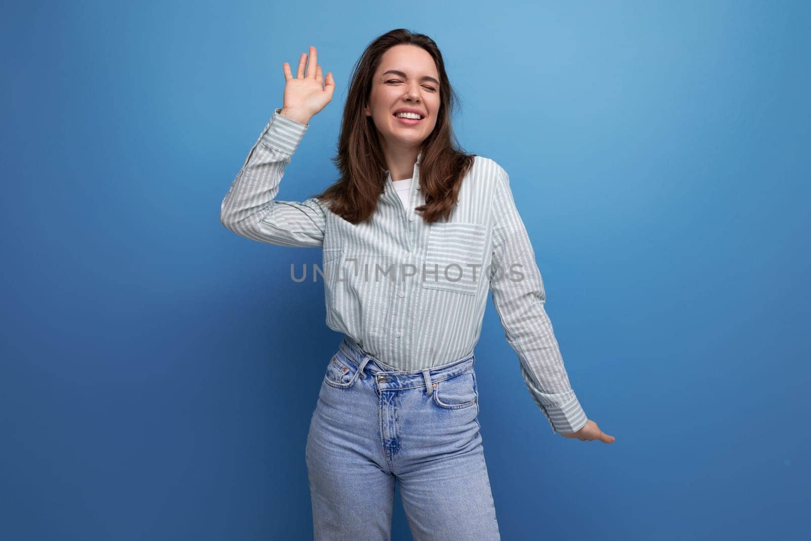 bright optimistic happy 25s woman with black hair in casual clothes on studio background with copy space.