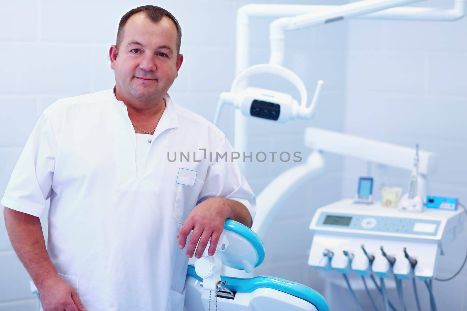 Portrait of a smiling dentist standing in dental clinic.