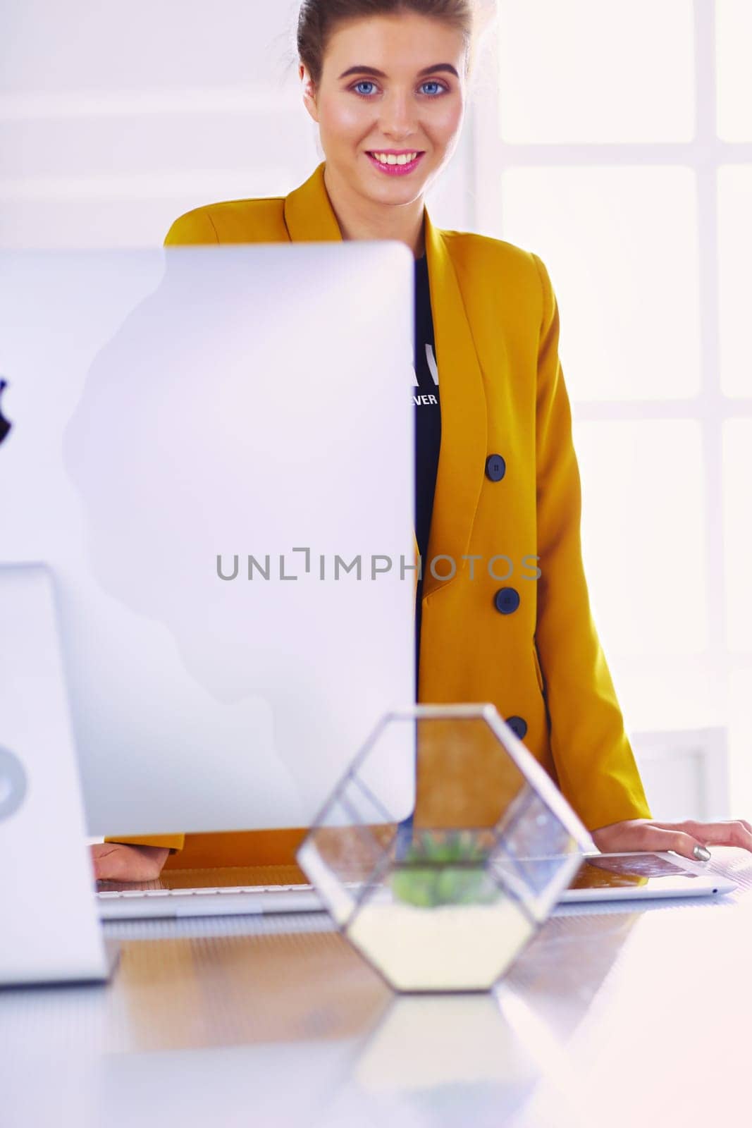 Portrait of a beautiful business woman standing near her workplace