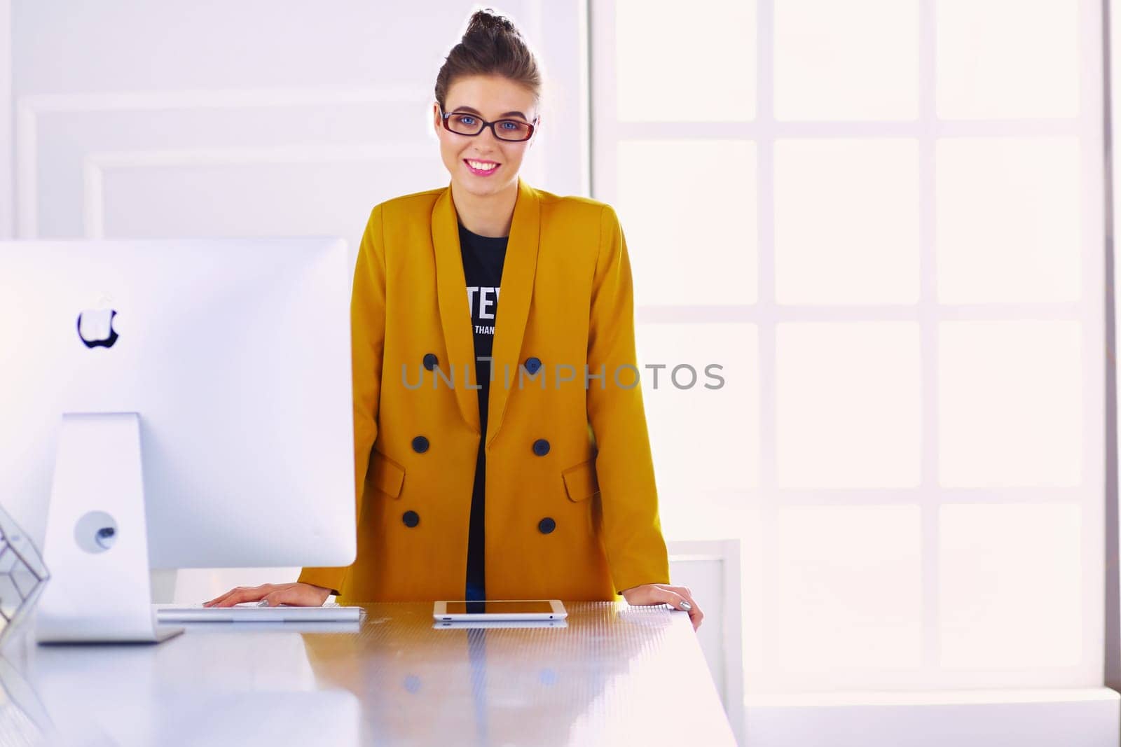 Portrait of a beautiful business woman standing near her workplace