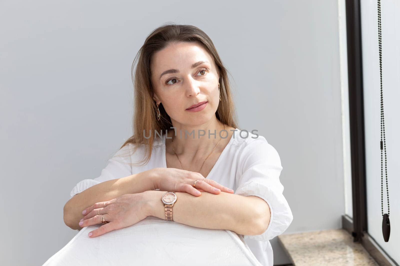 Portrait of Charming 40 yo Dermatologist in White Lab Coat Looking at Camera With Smile, Near Couch, Looking at Camera in Spa Salon. Horizontal Plane High quality photo