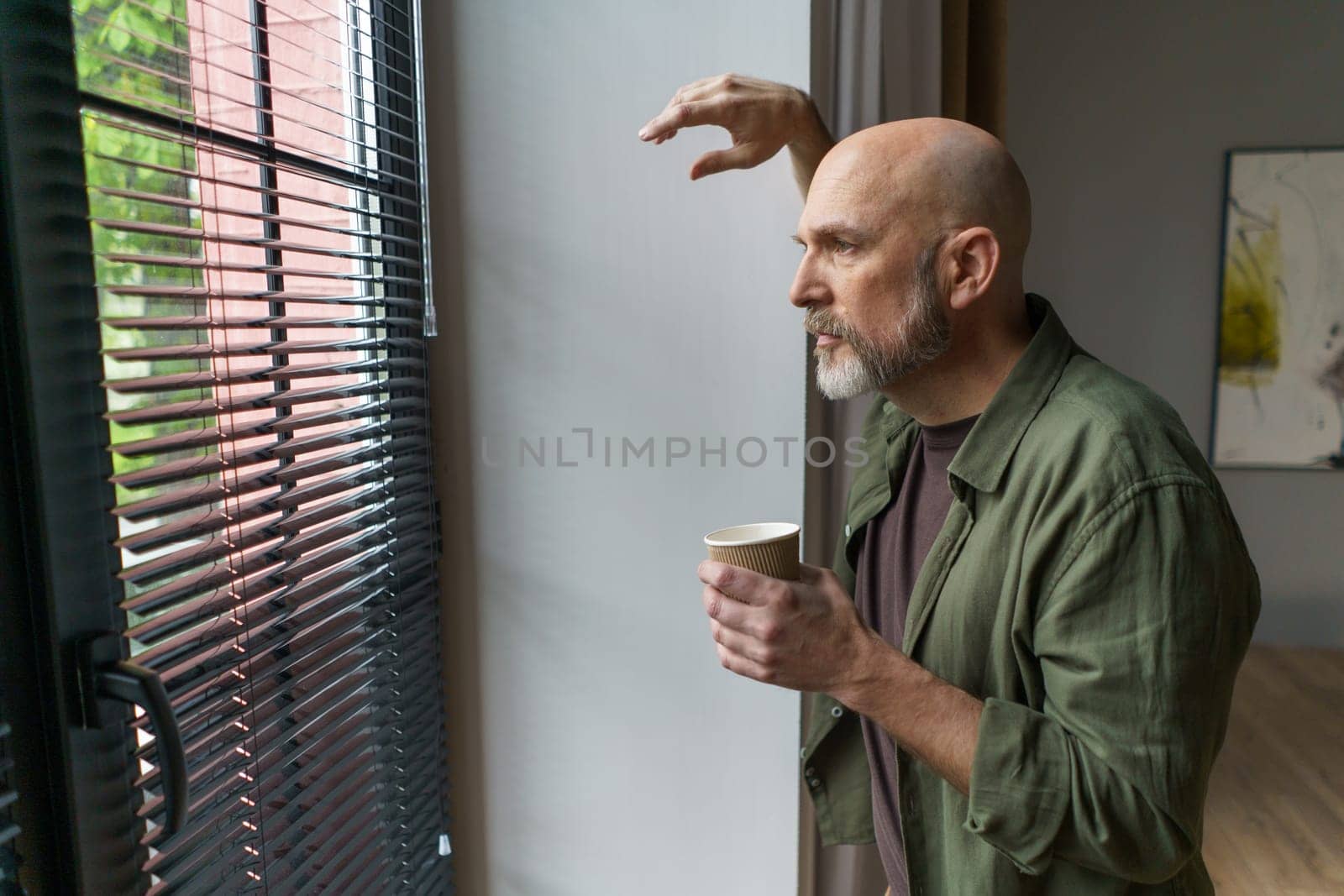 Happy old age, mature man radiates positivity from comfort of home. Positioned near window, emanating sense of contentment and joy. High quality photo