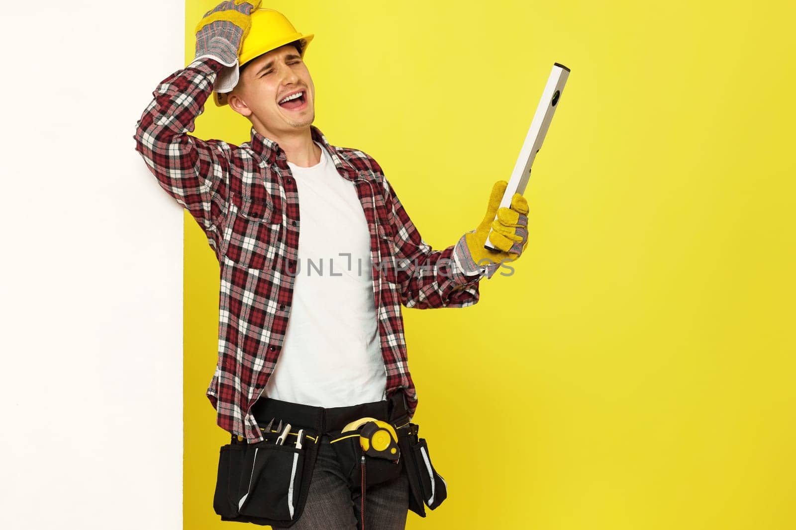 upset professional builder in work clothes in helmet with level . copy space for text