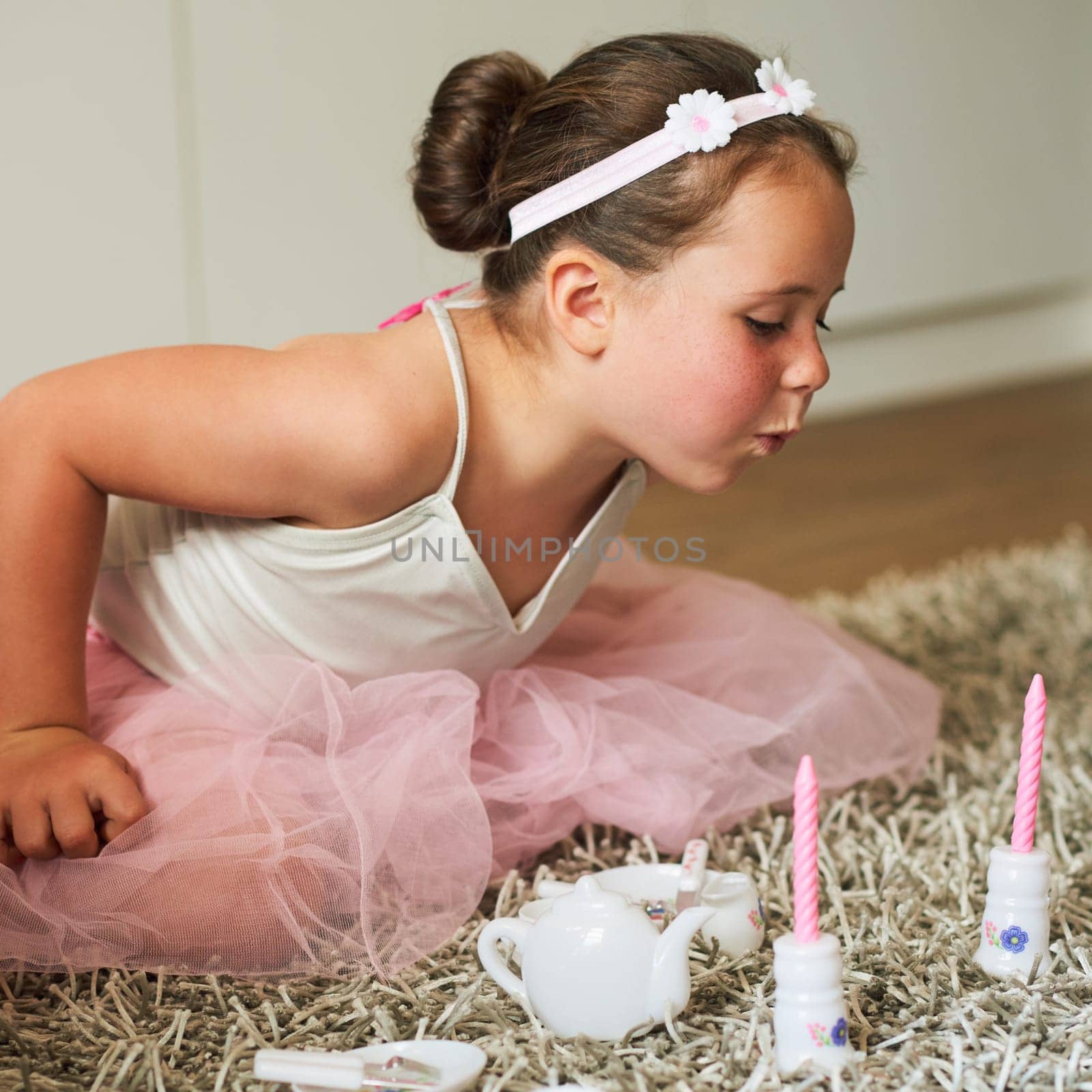 As girly as girlhood gets. an adorable little girl having a make believe party at home
