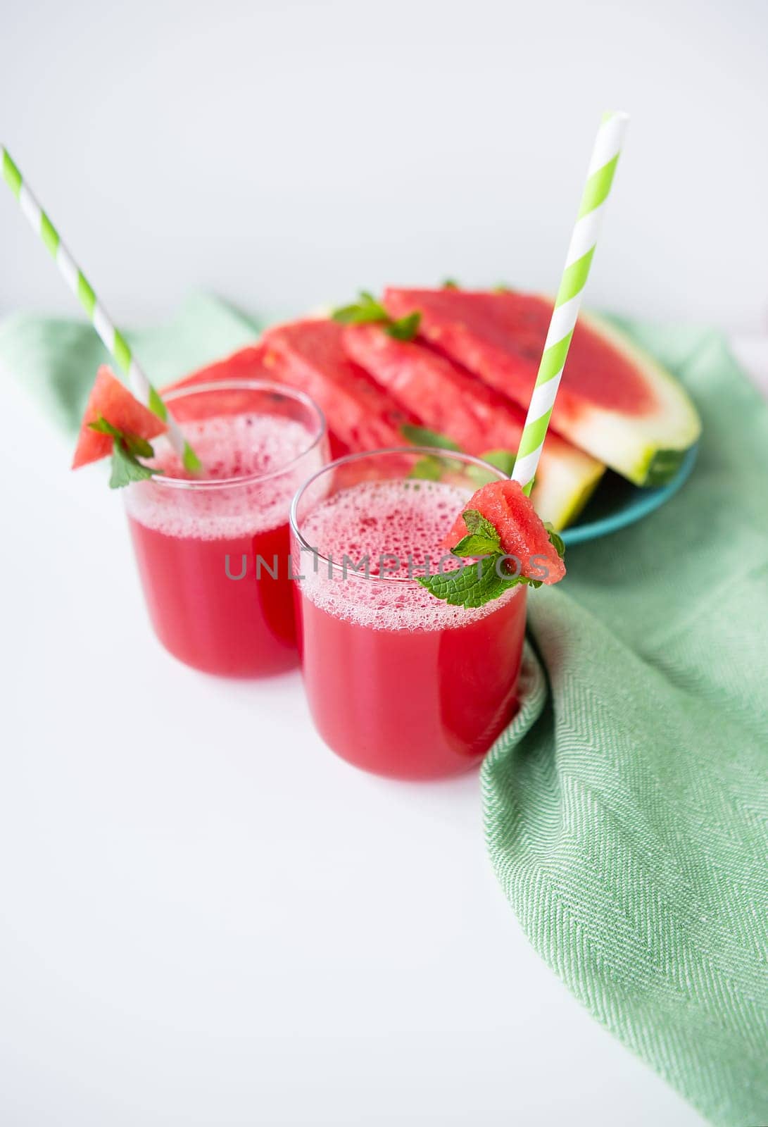 Juicy fresh watermelon juice in a glass along with a green tube, delicious and healthy summer food. by sfinks
