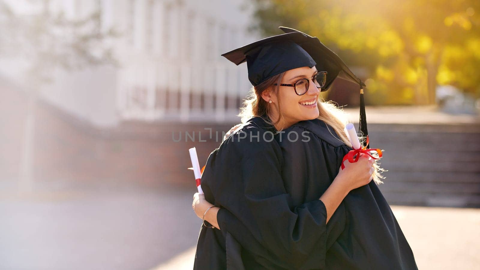 Friends, students and hug at graduation for college or university achievement. Women outdoor together for congratulations or celebrate education goal, success and future at school event for graduates by YuriArcurs